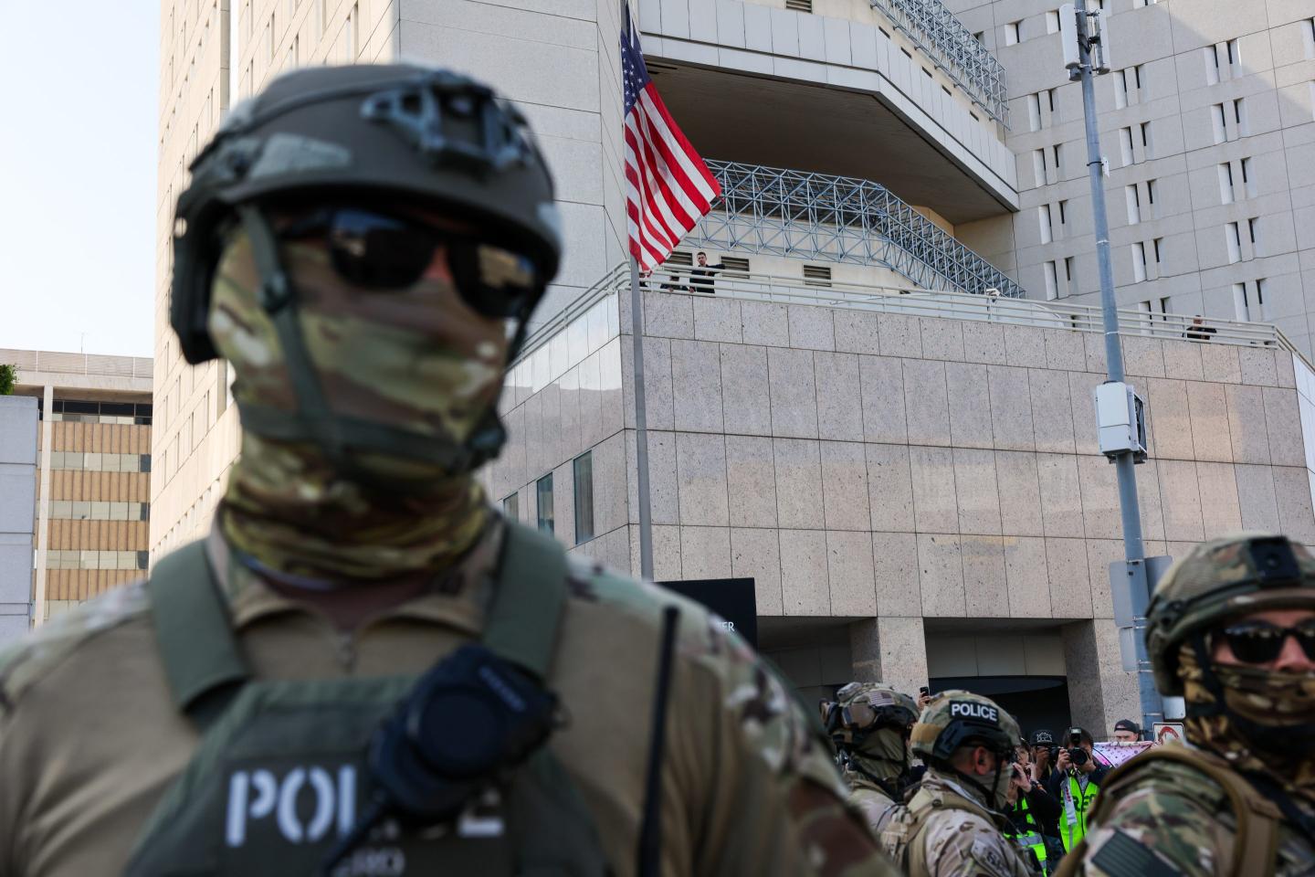 Federal agents guard outside of a federal building and Immigration and Customs Enforcement (ICE) detention center in downtown Los Angeles.