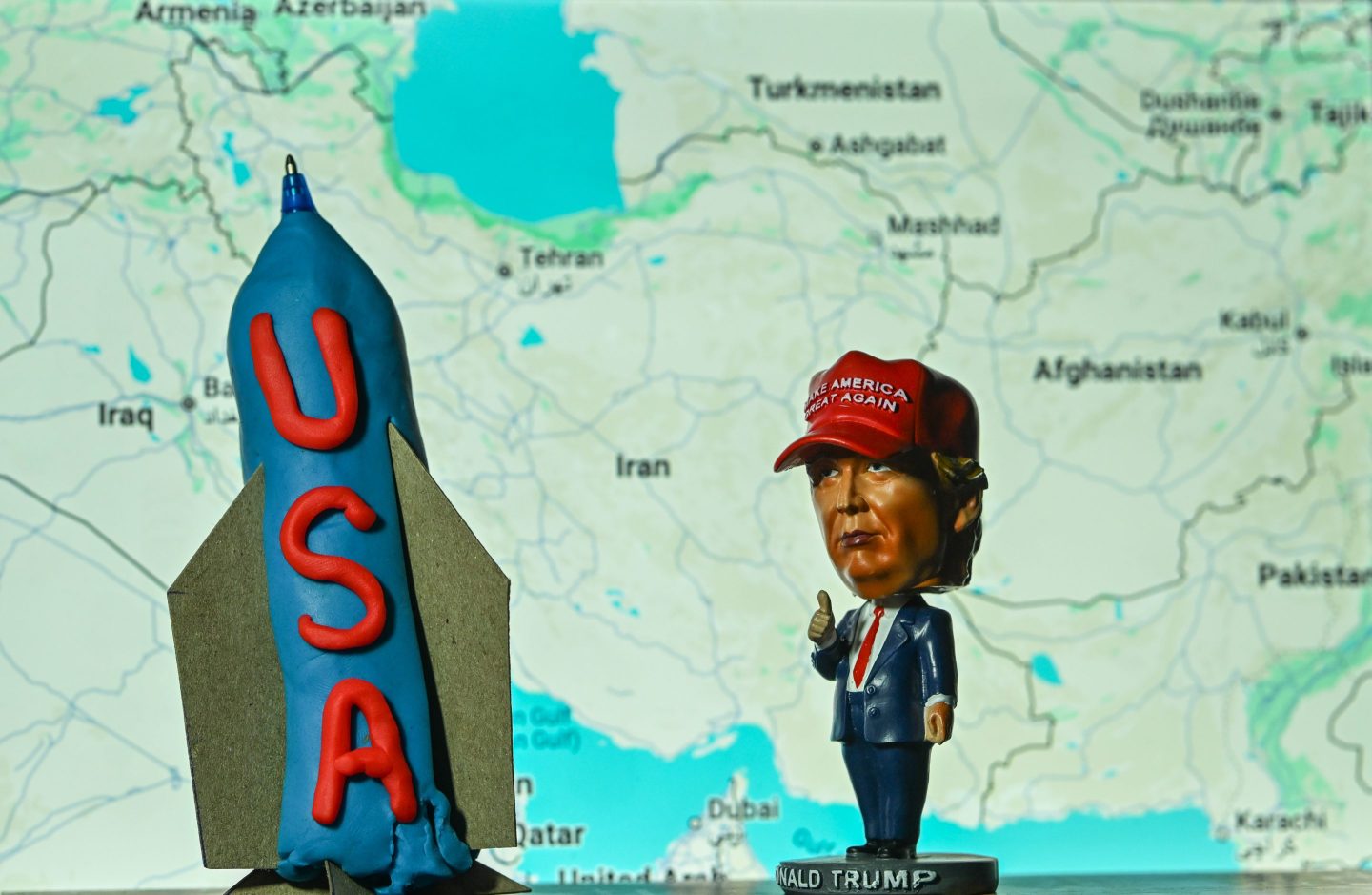 A miniature statue of U.S. President Donald Trump stands beside a model “bunker-buster” bomb, displayed in Alberta, Canada, on June 19, 2025.