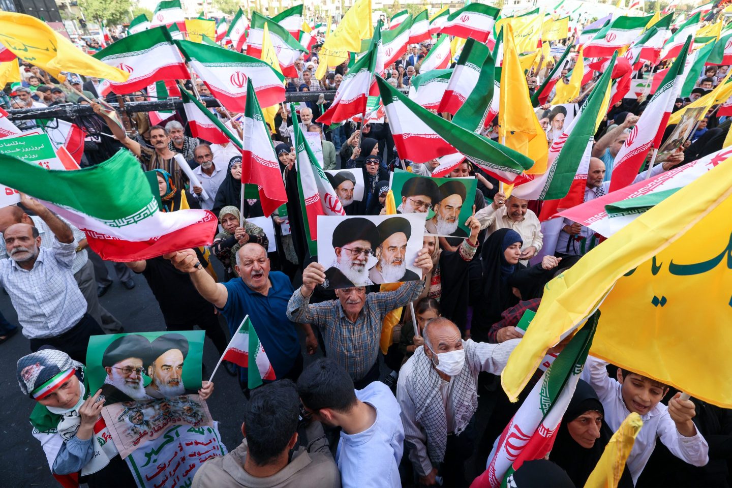 Iranians chant slogans, wave national flags, and hold portraits of Iranian supreme leader Ayatollah Ali Khamenei (L) and late supreme leader Ayatollah Ruhollah Khomeini, as they celebrate a ceasefire between Iran and Israel at Enghlab Square in the capital Tehran on June 24, 2025.