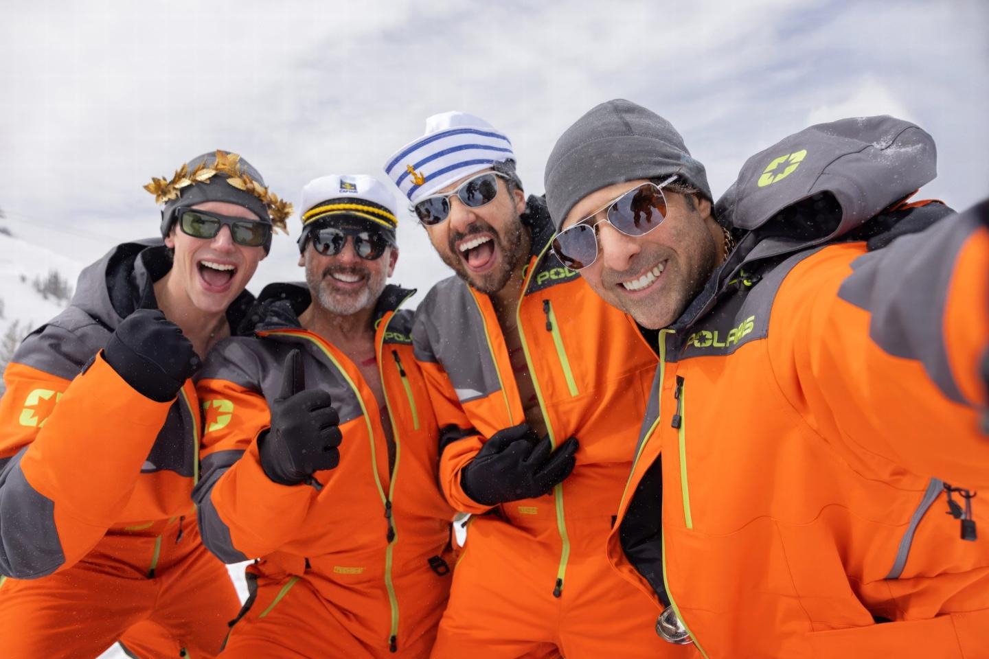 The four main characters of Mountainhead stand together for a selfie on a ski slope.
