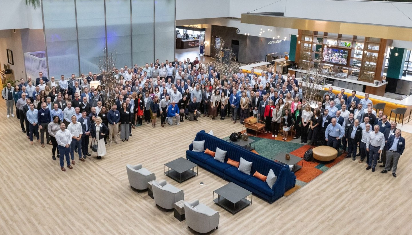 large group of people pose for a photo in a workplace