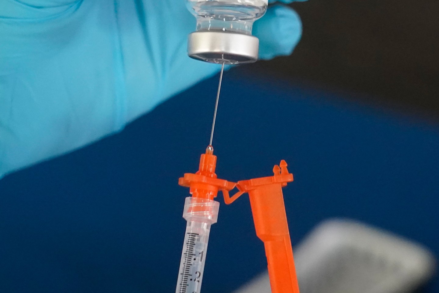 A nurse loads a syringe with a COVID-19 booster vaccine at an inoculation station in Jackson, Miss., Nov. 18, 2022.