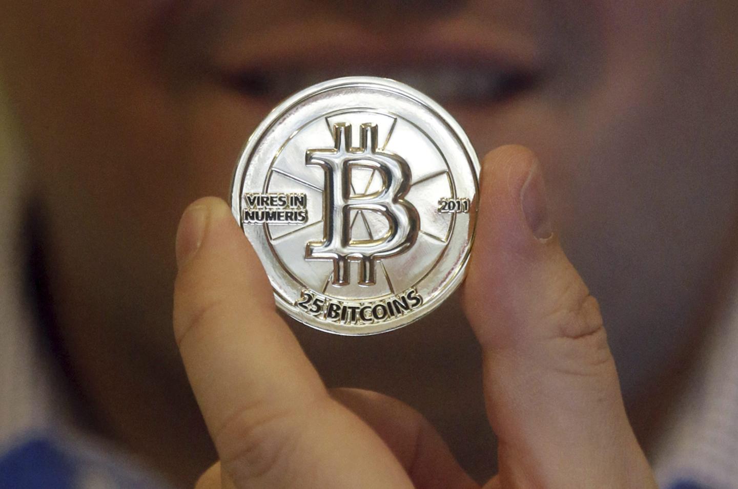 A Bitcoin token held in a hand