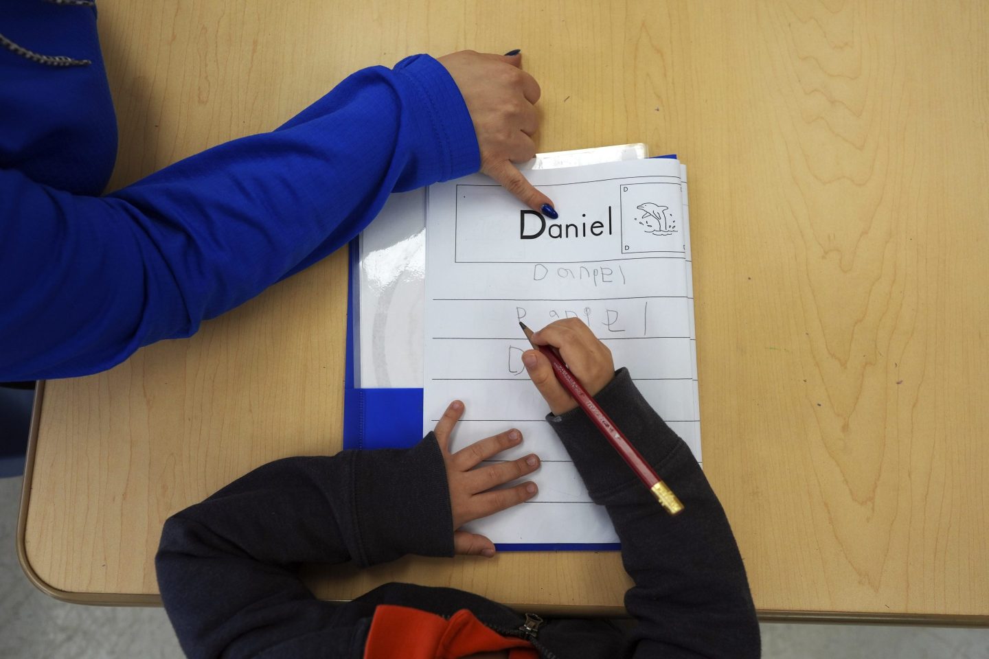 Easterseals Head Start program teaching assistant Tania Ortiz helps a student practice writing his name, Jan. 29, 2025, in Miami.