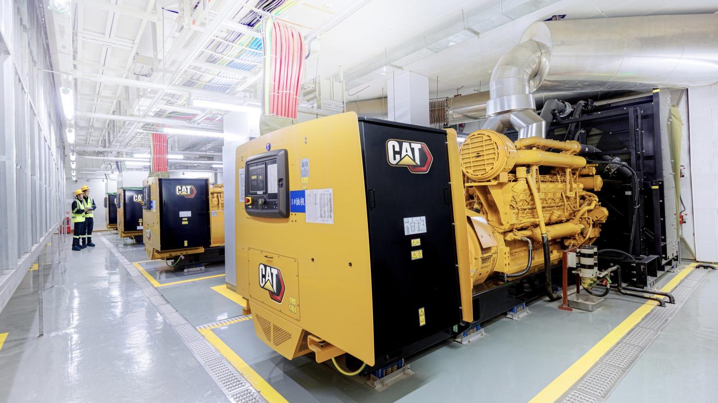 Caterpillar power generators are shown in a row at a data center facility. The generators can be used for primary or backup power.