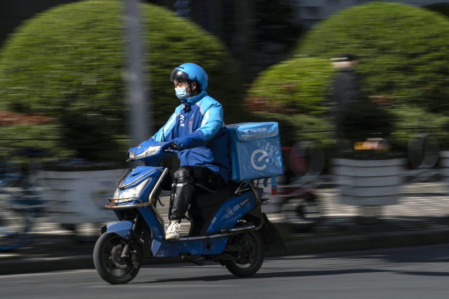 A delivery courier for Ele.me, Alibaba Group Holding Ltd.'s food-delivery platform, travels along a road in Shanghai, China, on Monday, March 22, 2021.