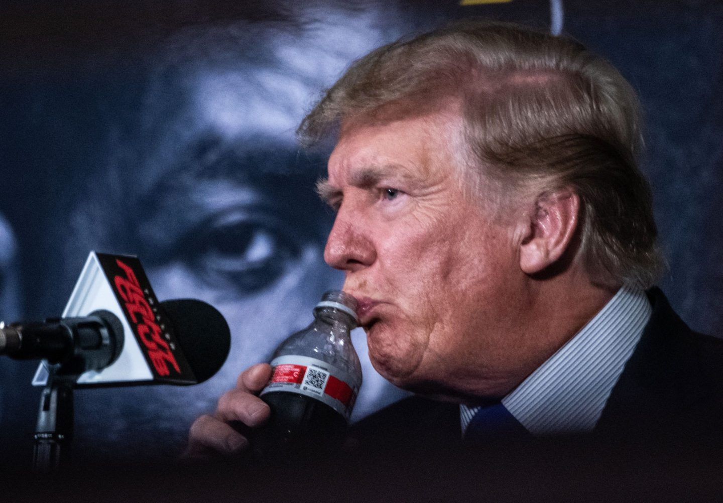 President Donald Trump drinks from a soda bottle during a press conference