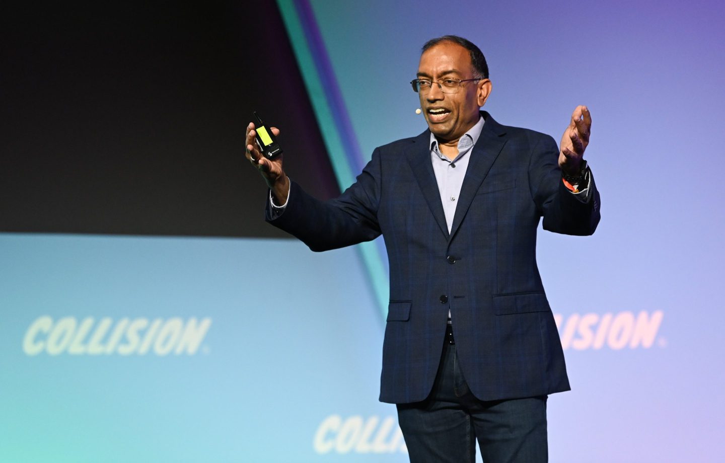 Walmart exec Suresh Kumar gesticulates onstage at a tech conference