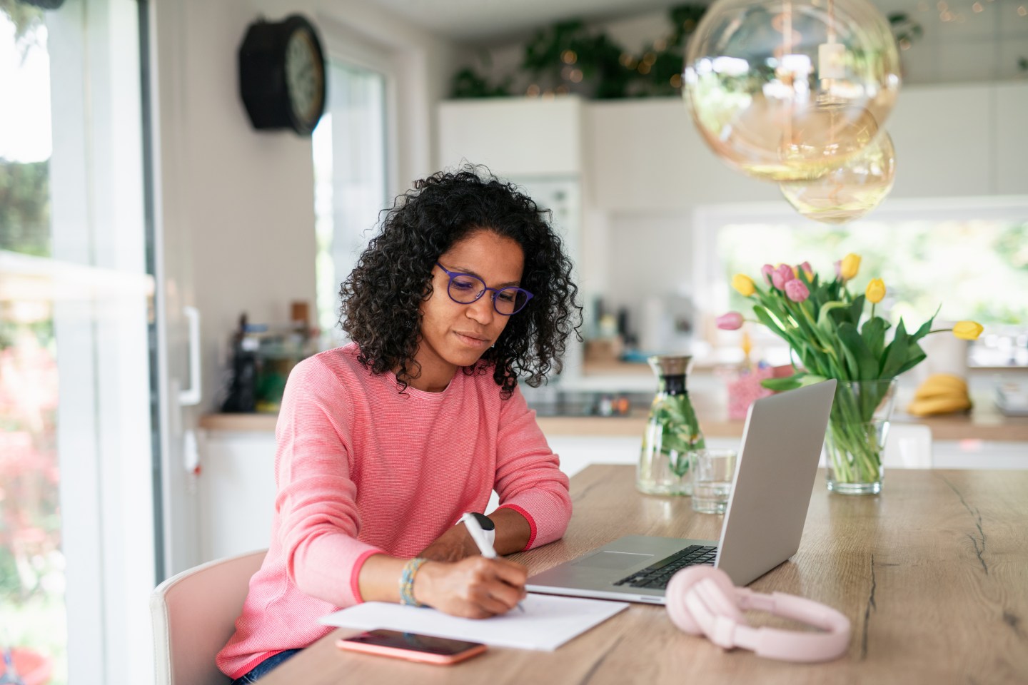 young woman working on a laptop at a kitchen table