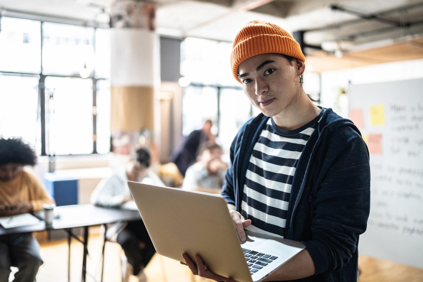 Gen Z worker holding a laptop