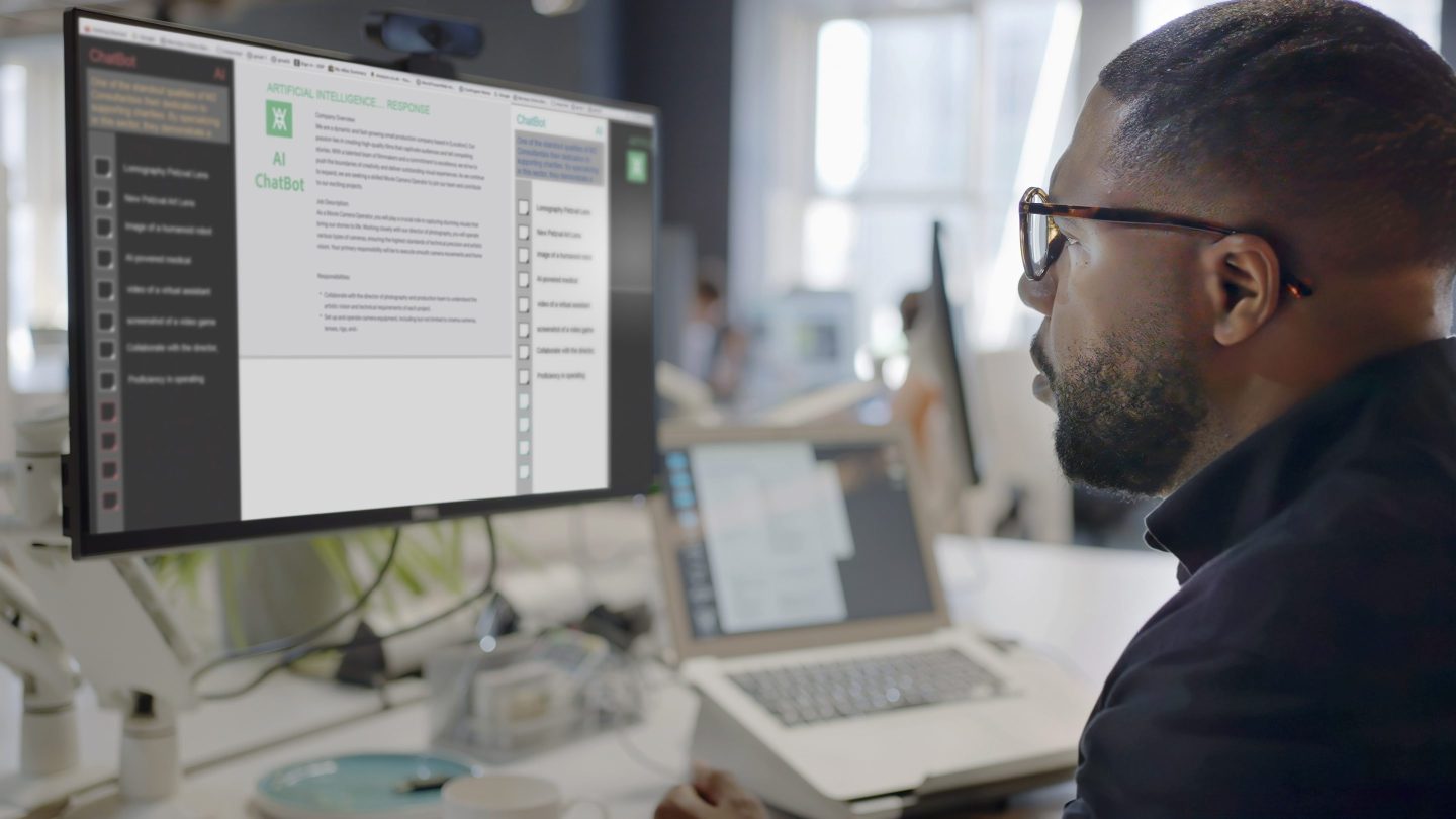 Stock image showing a Black man’s face looking into a computer screen.