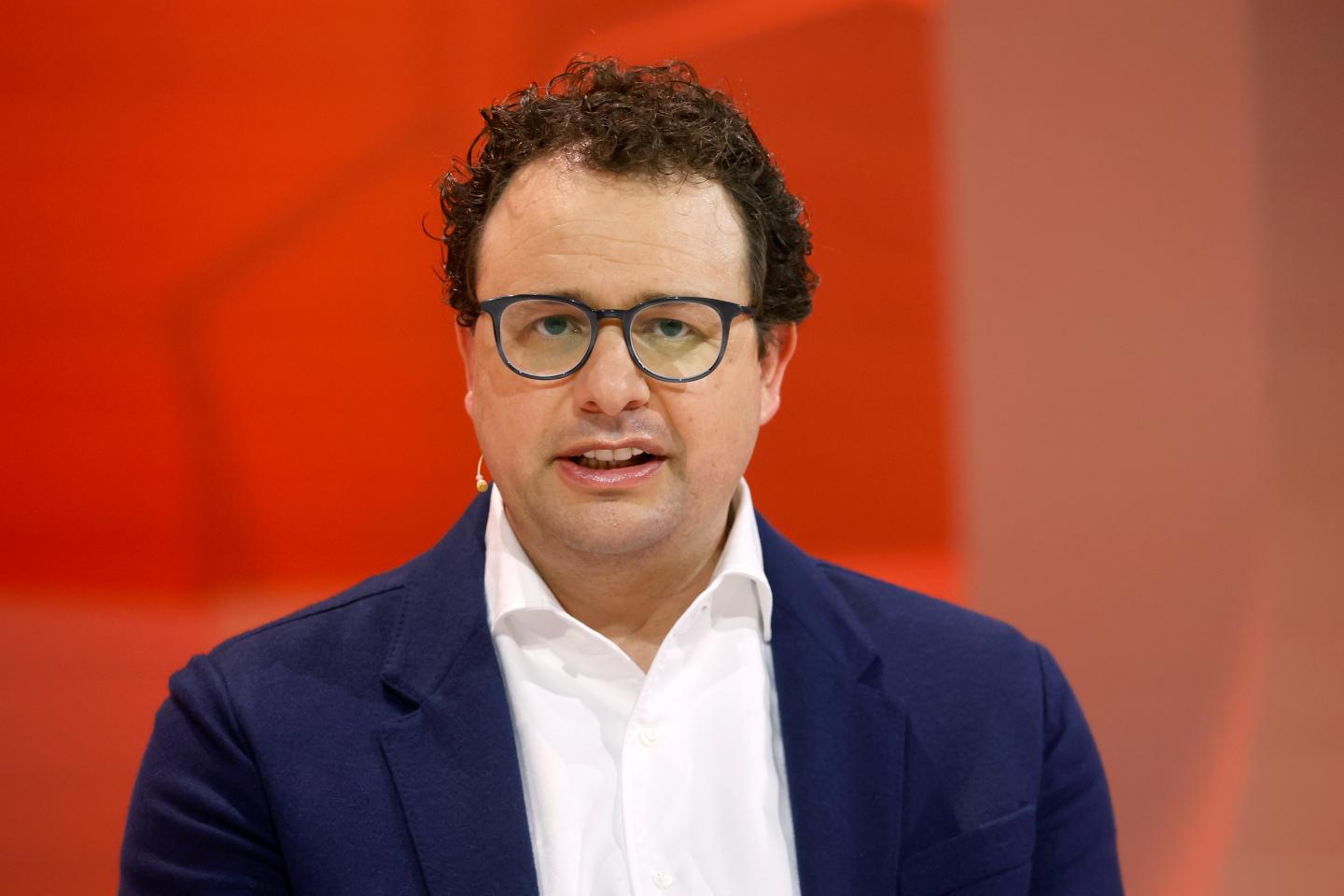 Co-founder and CEO of Anthropic, Dario Amodei in front of a red background.