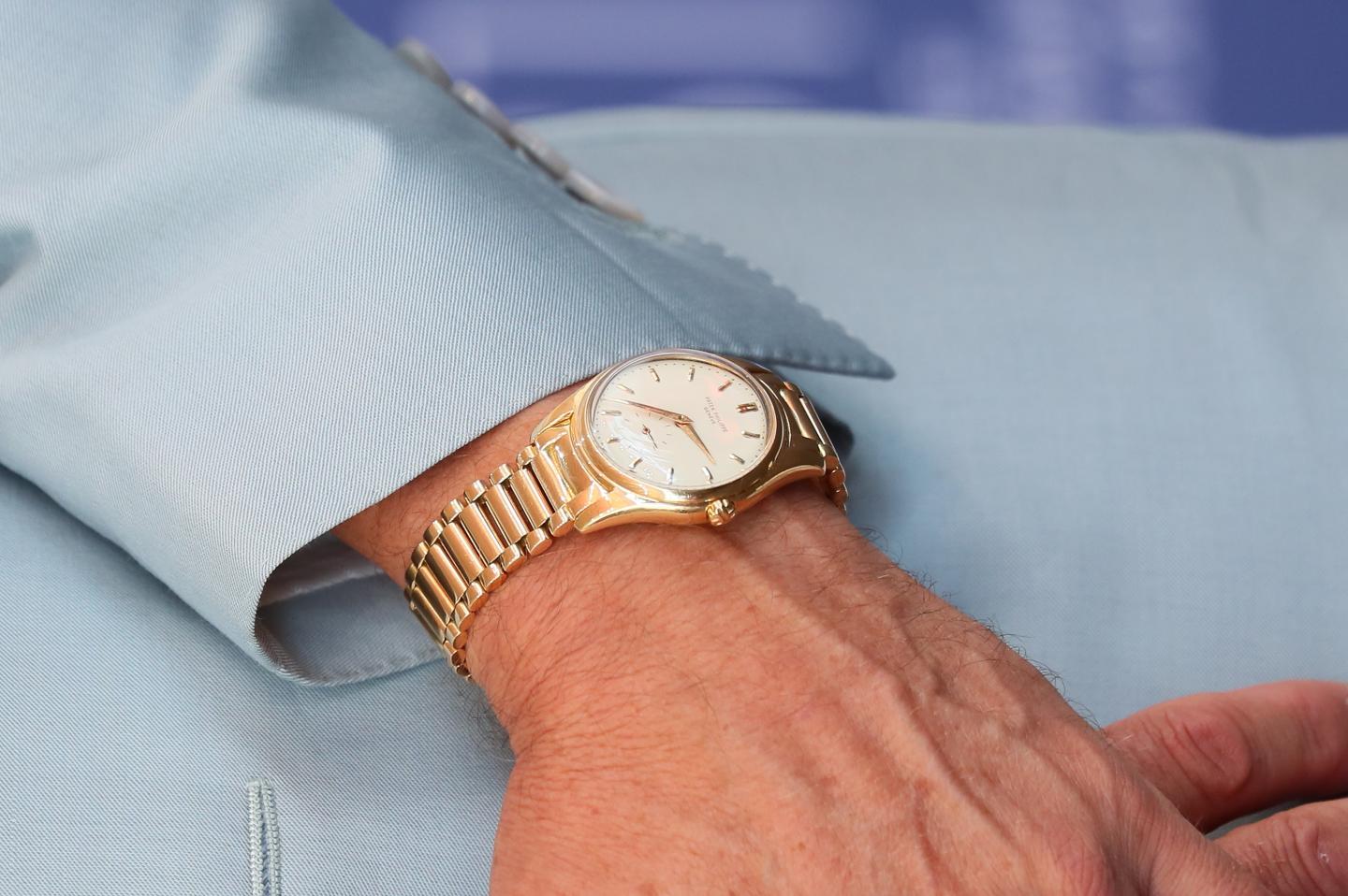 A gold Patek Philippe watch on a man's wrist.