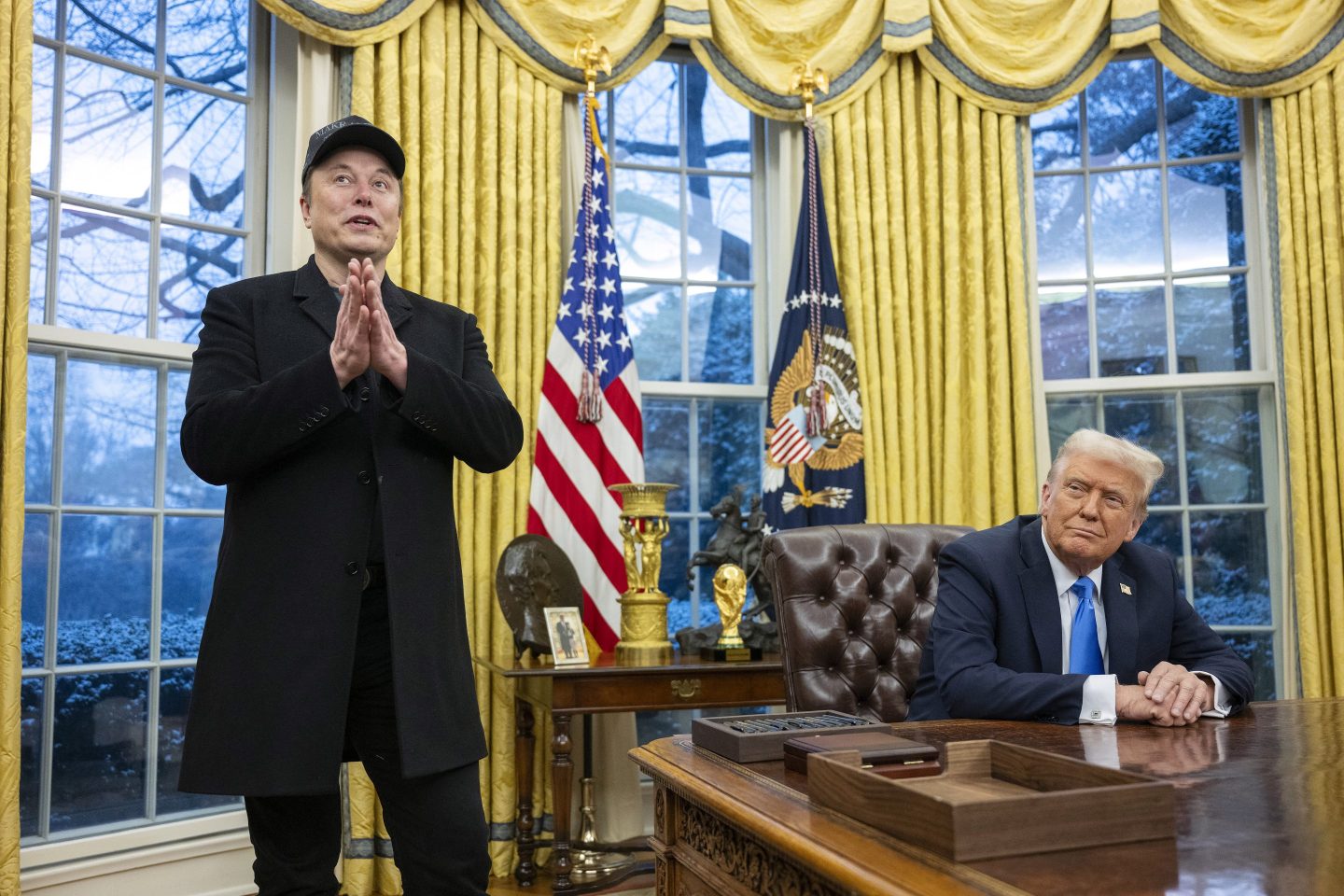 Elon Musk speaks as US President Donald Trump looks on in the Oval Office of the White House
