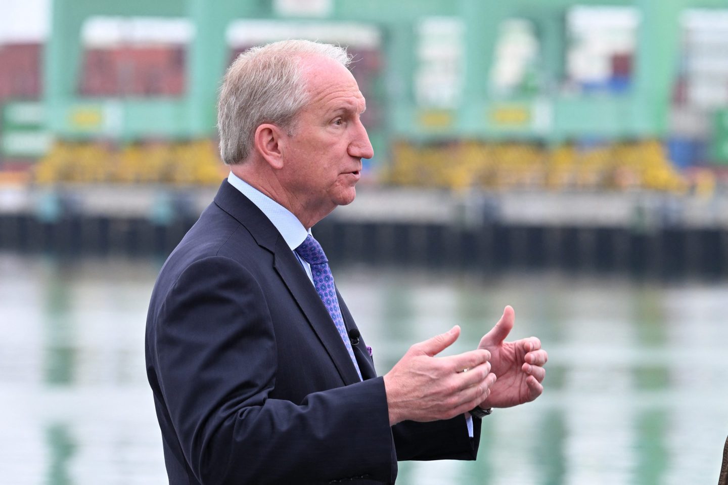 Gene Seroka looks to his right as he speaks in a shipyard.
