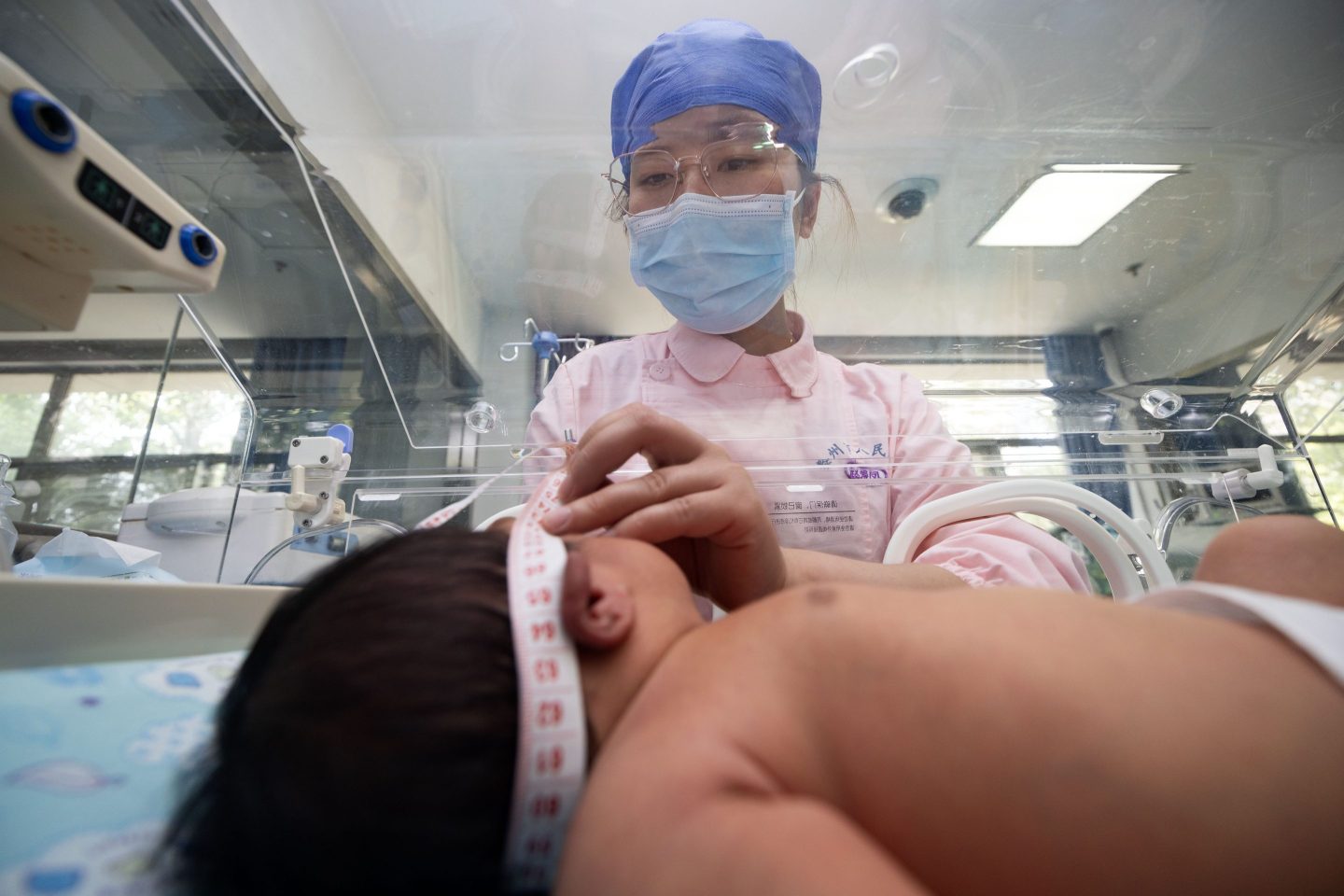 A nurse examining a newborn baby in China
