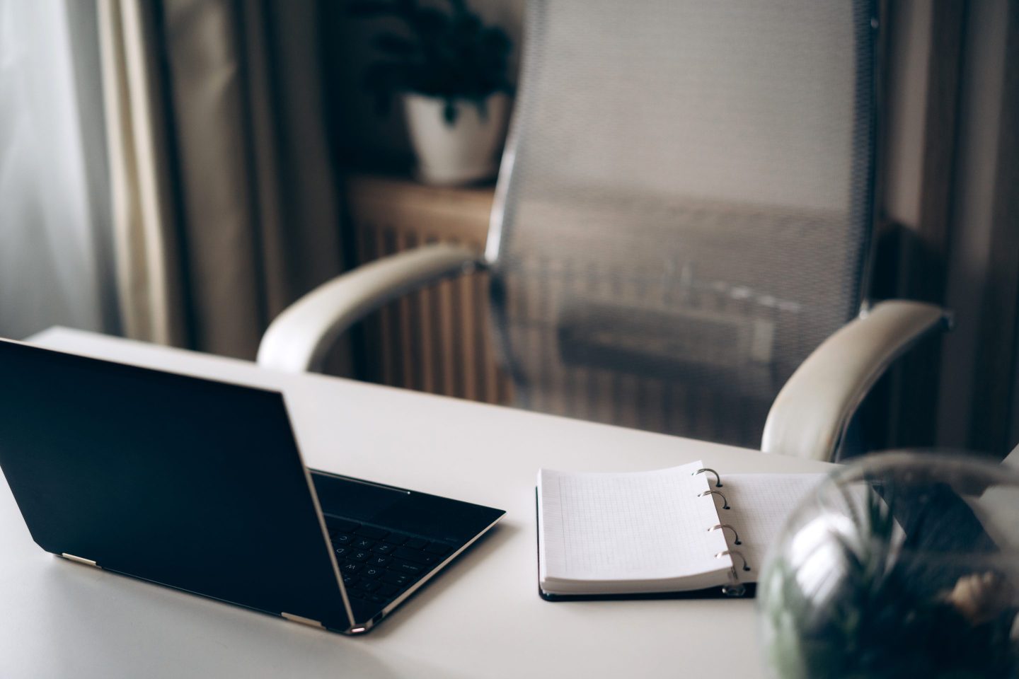 Empty desk with laptop and notebook for notes