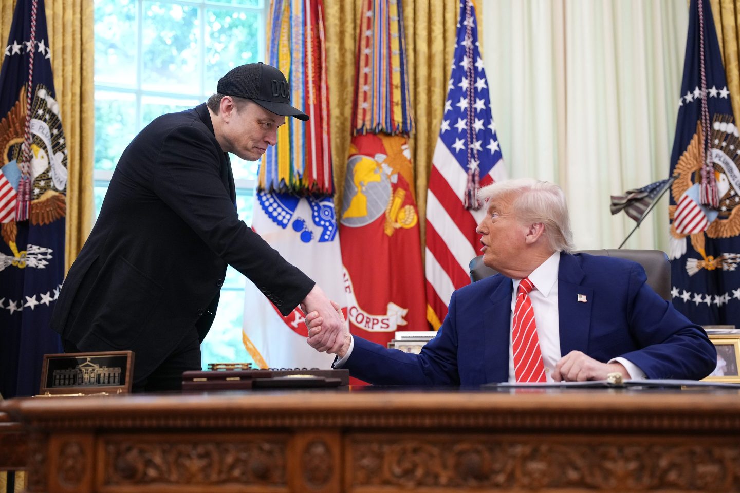 xAI owner Elon Musk (left) shakes hands with President Donald Trump.