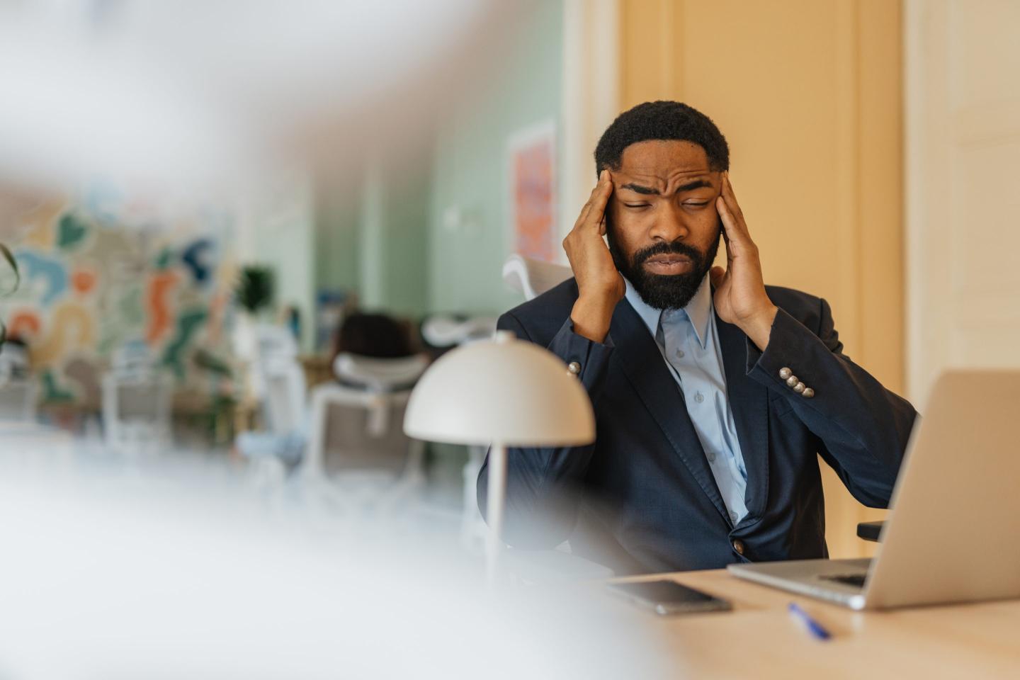 Businessman with headache at his office desk