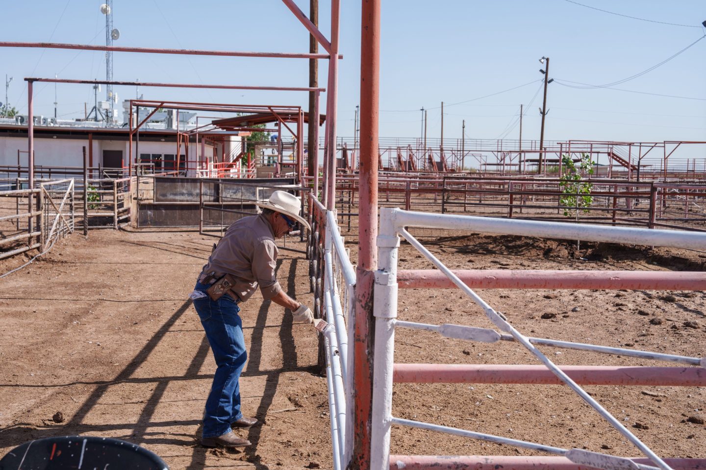 A worker paints a railing next to empty corrals at the Union Ganadera Chihuahua cattle import facility in Santa Teresa, N.M. on June 20, 2025.