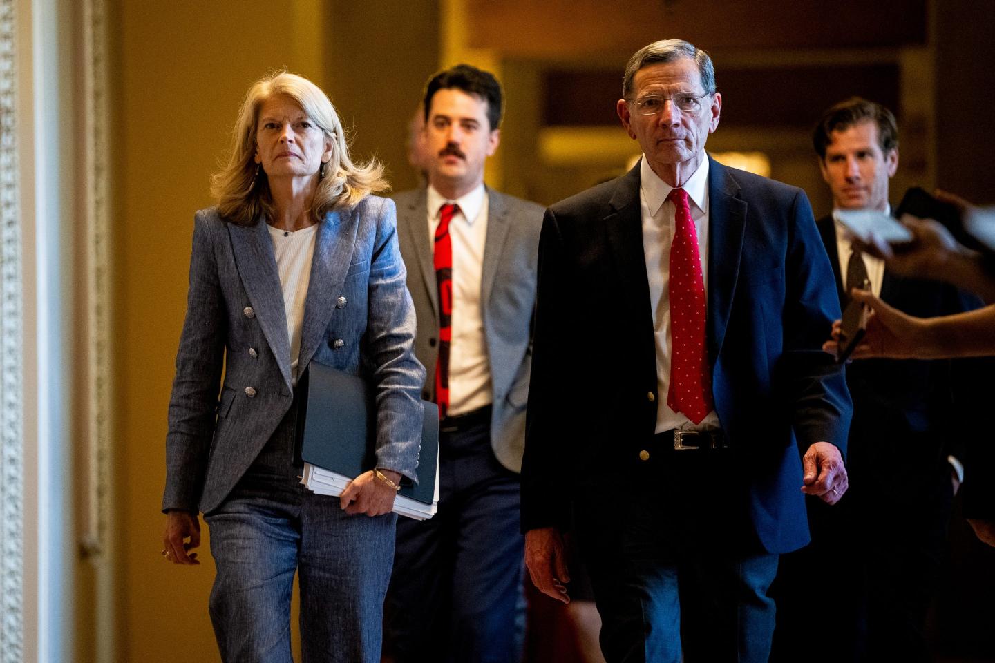 Lisa Murkowski and John Barrasso walk down a hallway
