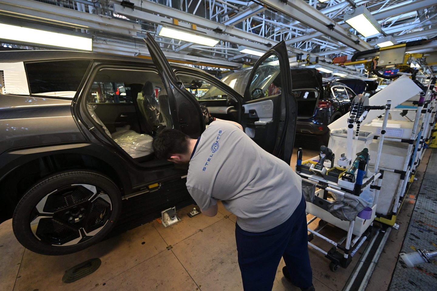 An employee works on the new Citroen C5 Aircross' production line in the Stellantis car maker plant in Chartres-de-Bretagne, near Rennes, western France, on July 3, 2025.