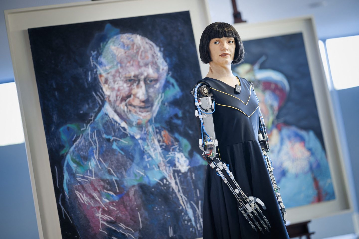 Ultra-realistic humanoid artist robot Ai-Da looks on in front of paintings of Britain's King Charles III and Queen Elizabeth II, displayed on the sidelines of the AI for Good Global Summit organised by International Telecommunication Union (ITU) in Geneva, on July 9, 2025.