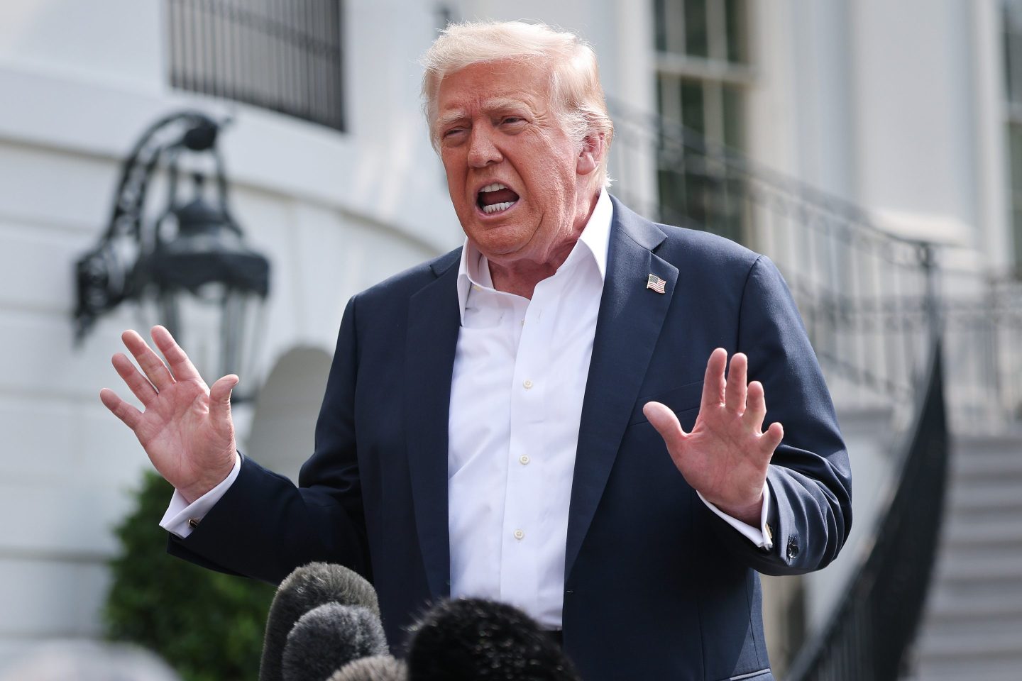 President Donald Trump answers questions while departing the White House on July 11.