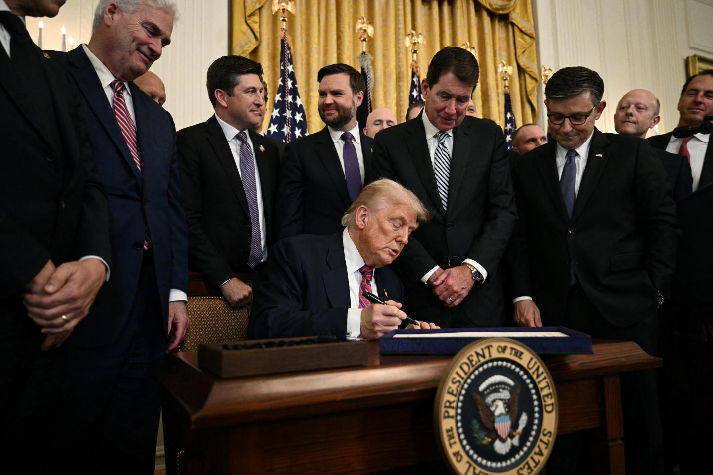US President Donald Trump signs the GENIUS Act (Guiding and Establishing National Innovation for US Stablecoins Act), which codifies the use of stablecoins -- cryptocurrencies pegged to stable assets like the US dollar or US bonds -- in the East Room of the White House in Washington, DC, on July 18, 2025.