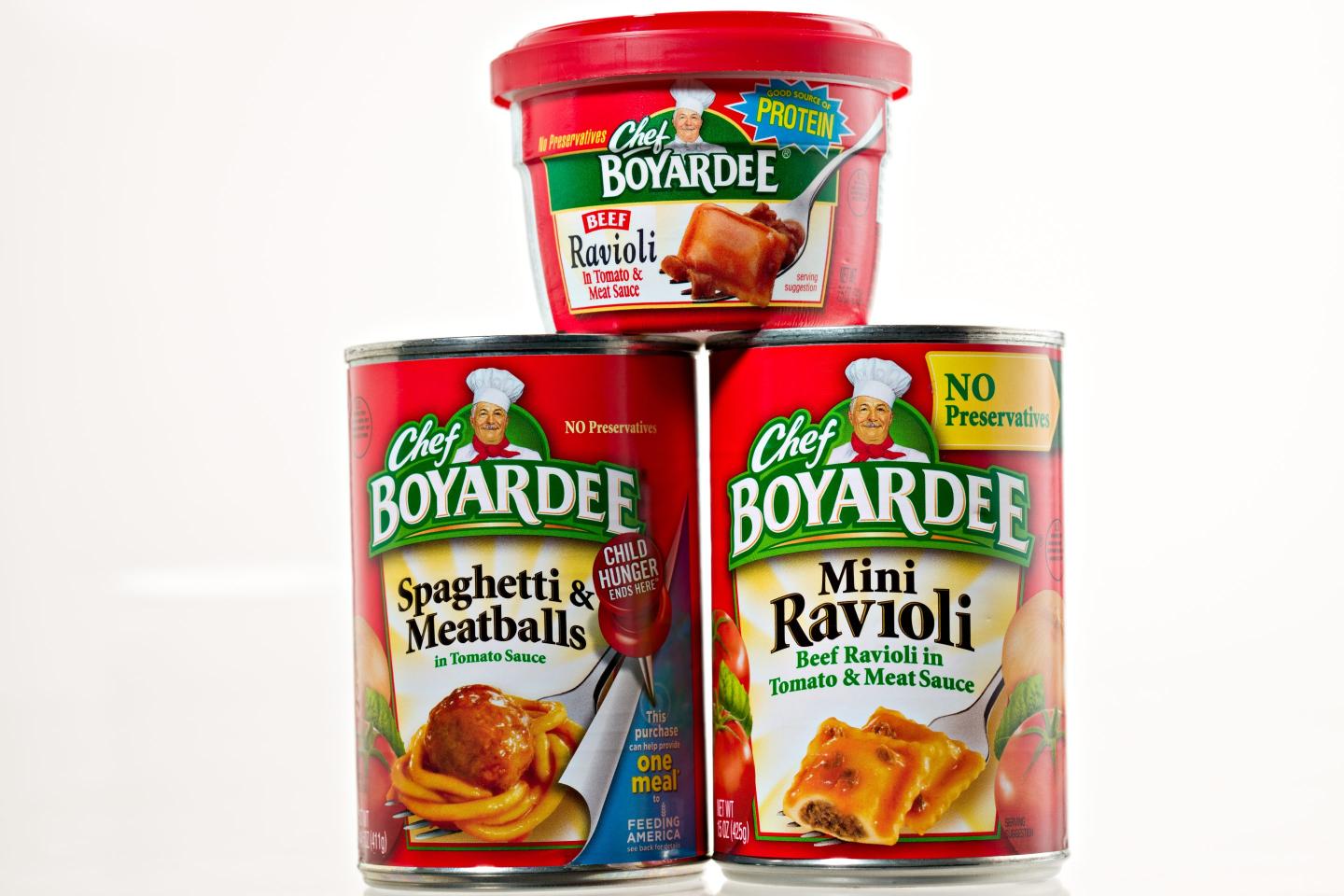 Two cans of Chef Boyardee, with a microwaveable cup version on top