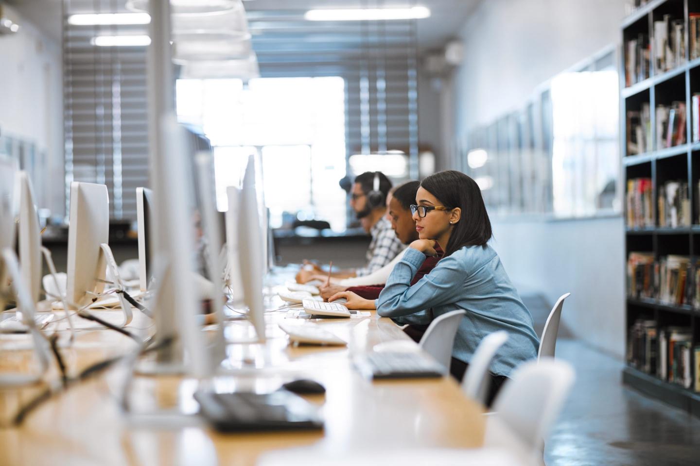 Students in a computer lab sit typing on computers.
