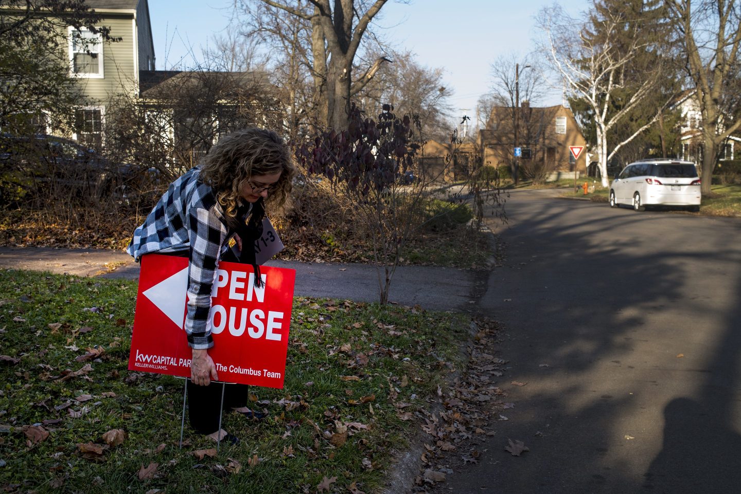 woman removing open house sign