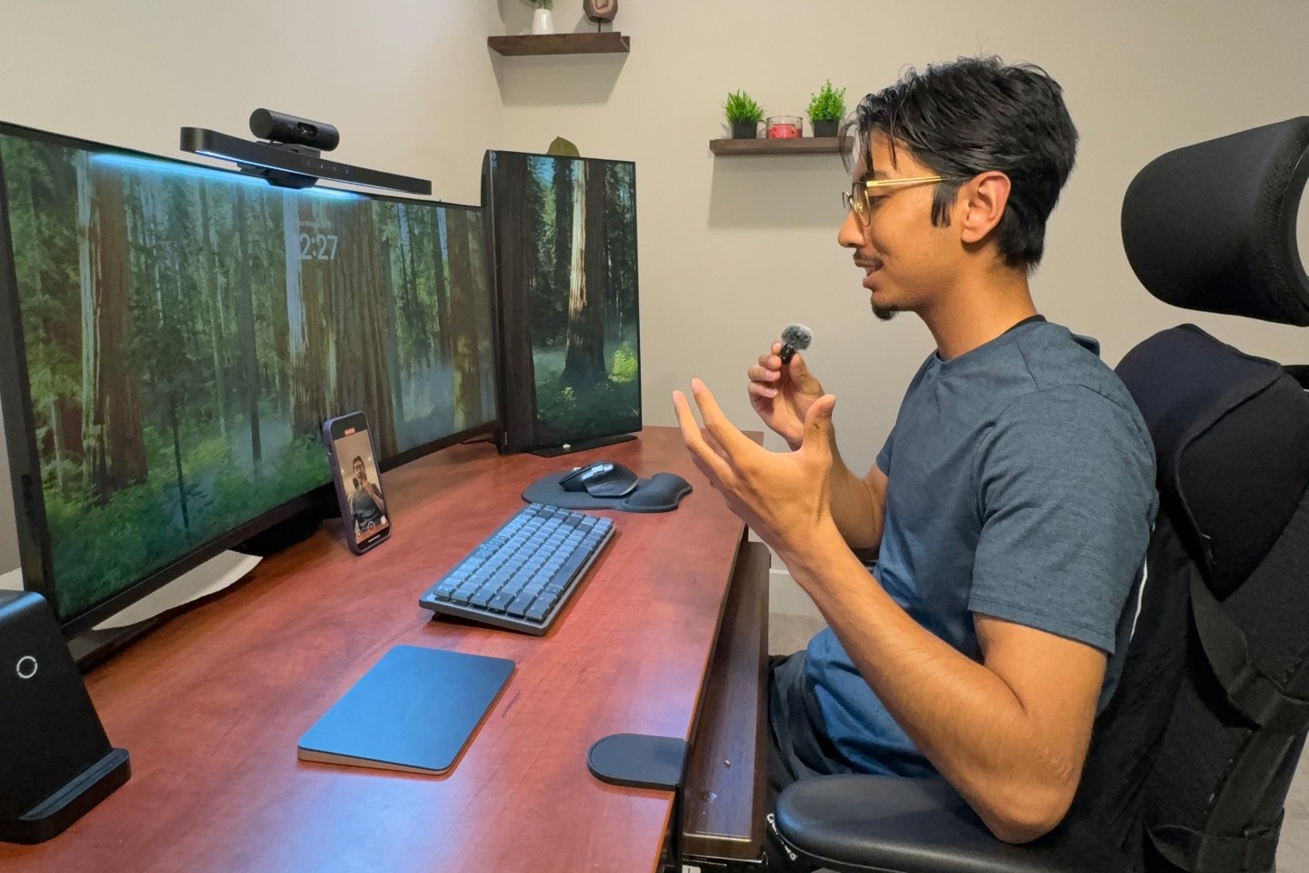 Nav Karmacharya, a 23-year-old cybersecurity analyst, records himself speaking into a microphone for a TikTok, his phone propped up on his work desk.