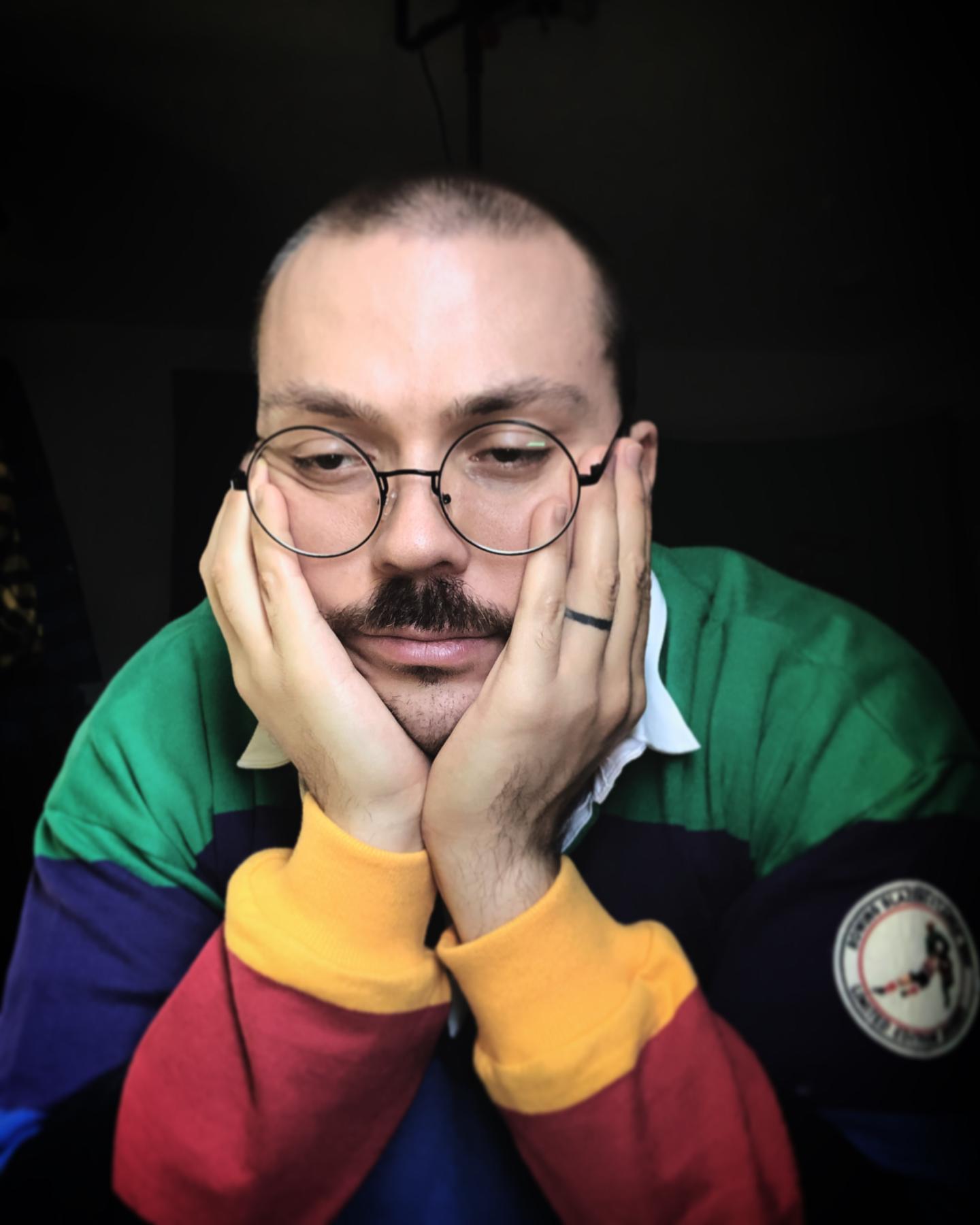 Anthony Fantano with his head in his hands