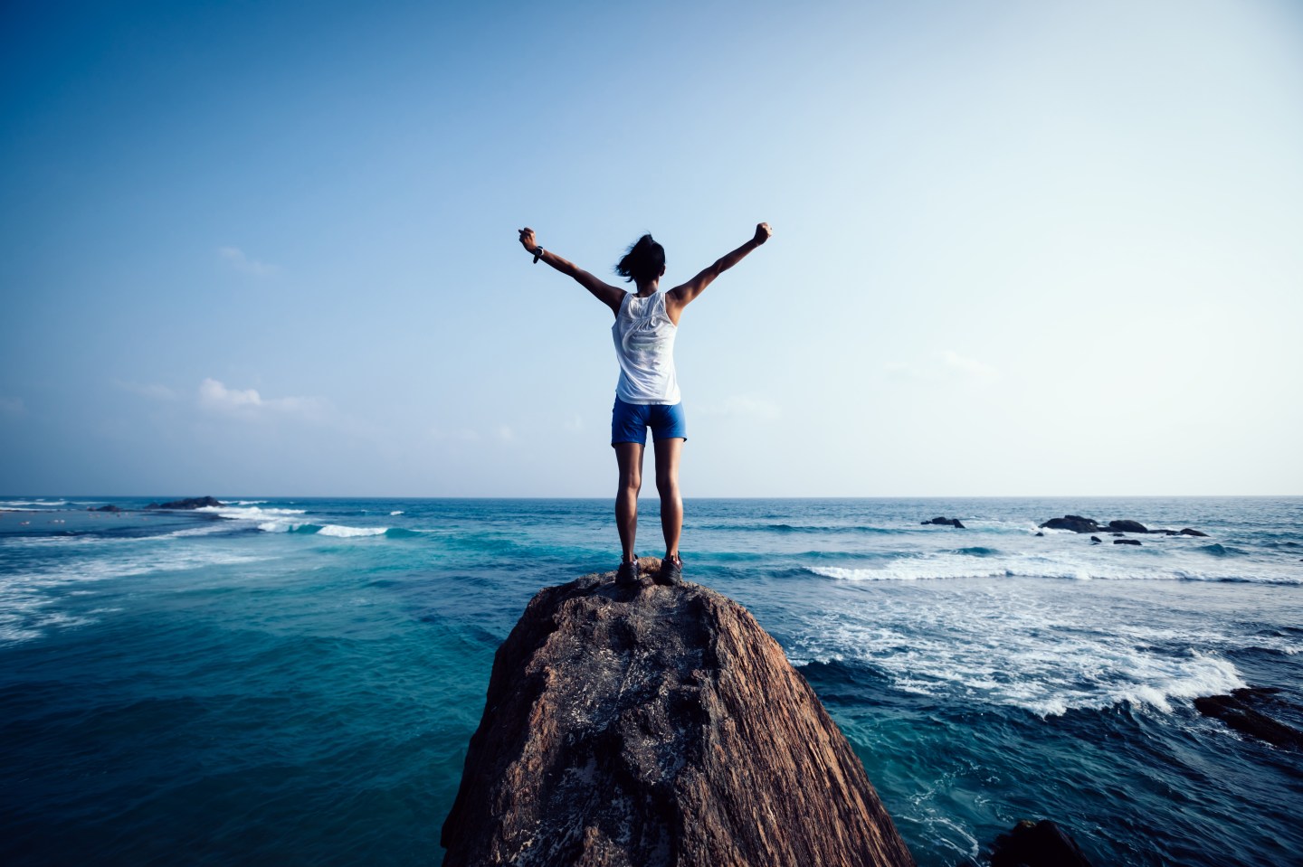 Photo: A woman at the summit of a small peak.