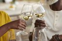 Heterosexual couple toasting wineglasses at winery on weekend.