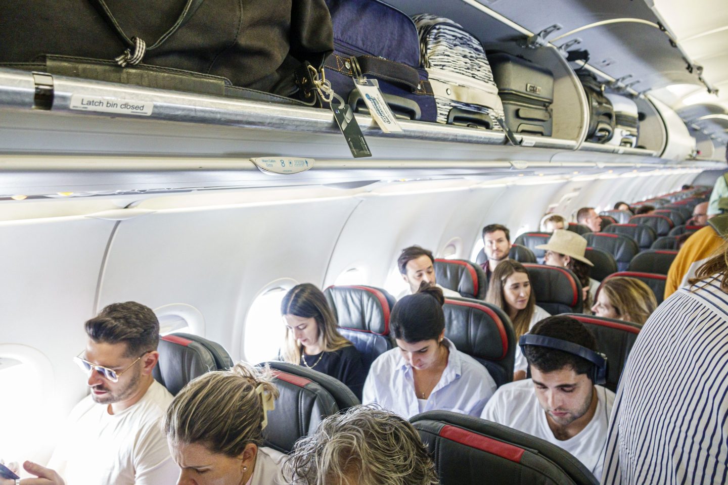 Passengers line seats in a large aircraft.