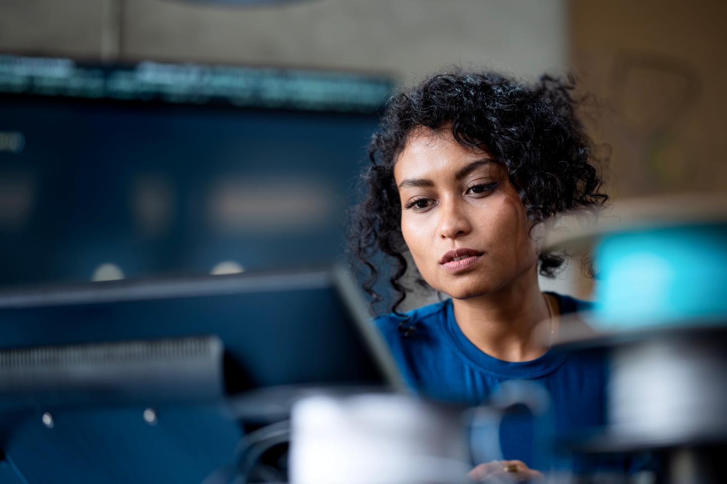 Tech worker looking at a computer.
