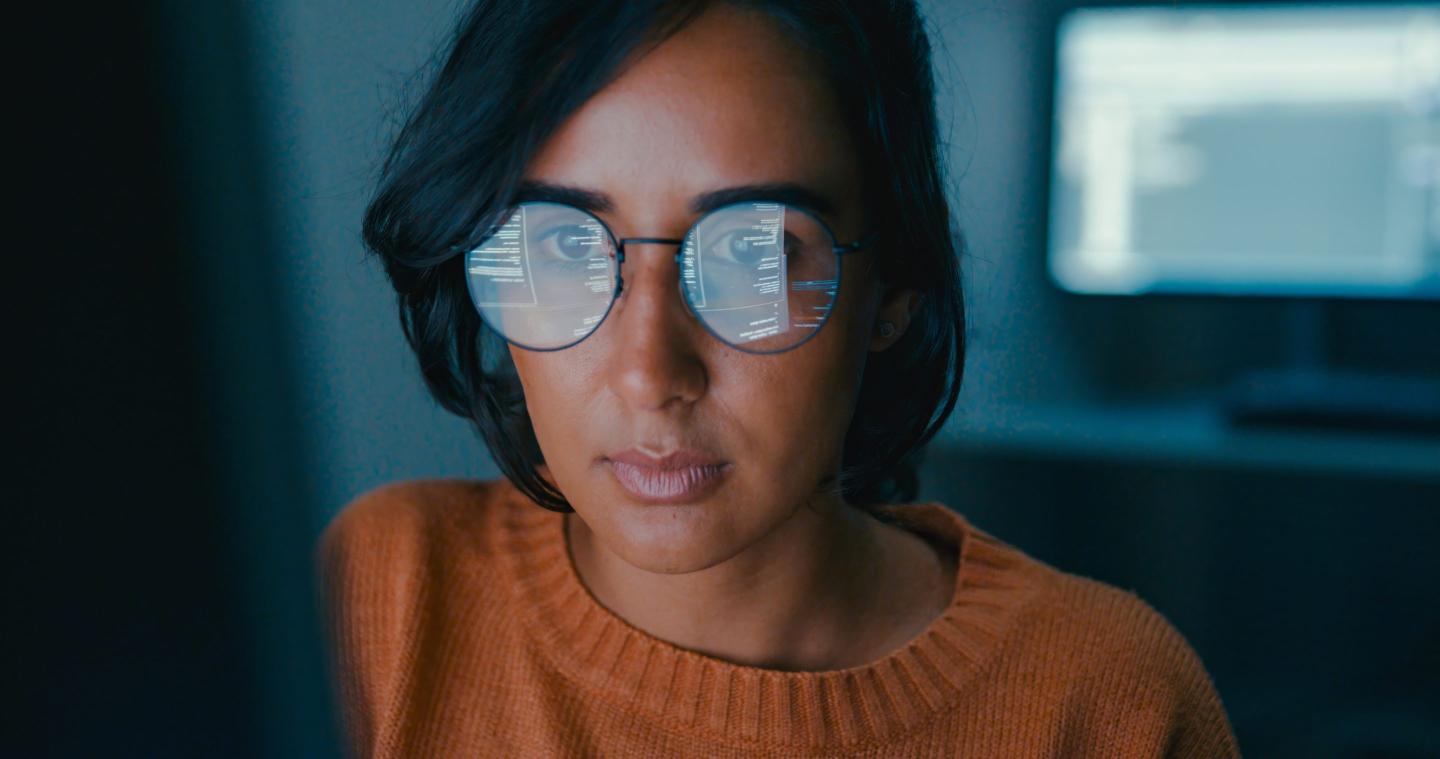A young woman in front of a computer screen