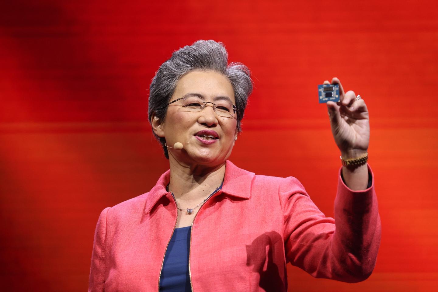 Lisa Su hopes up a semiconductor chip during a presentation.