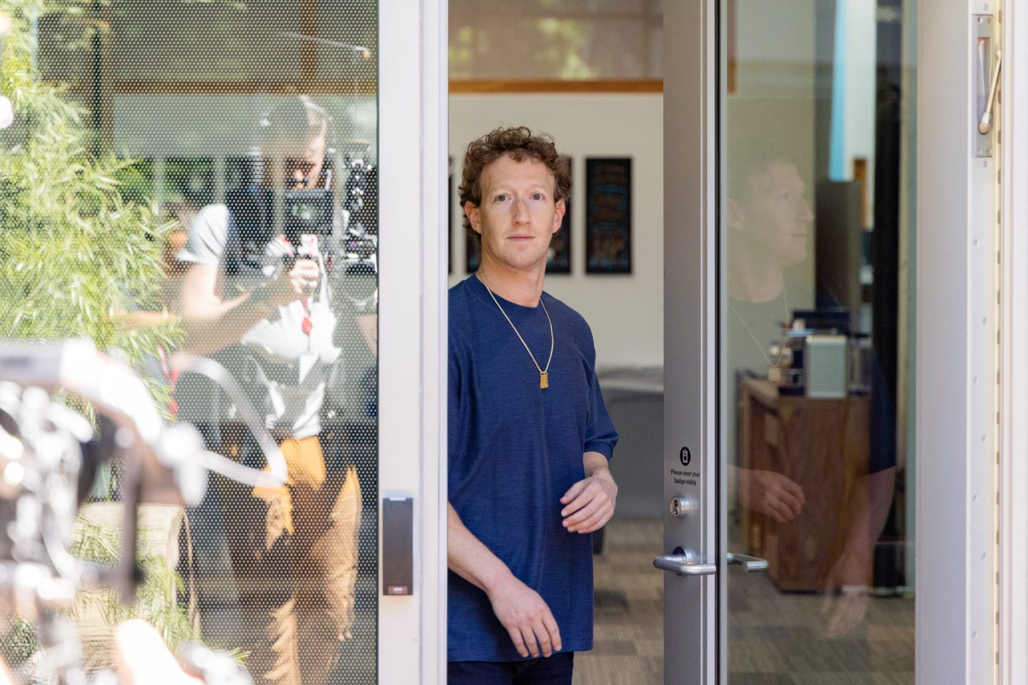 Mark Zuckerberg stands in a doorway
