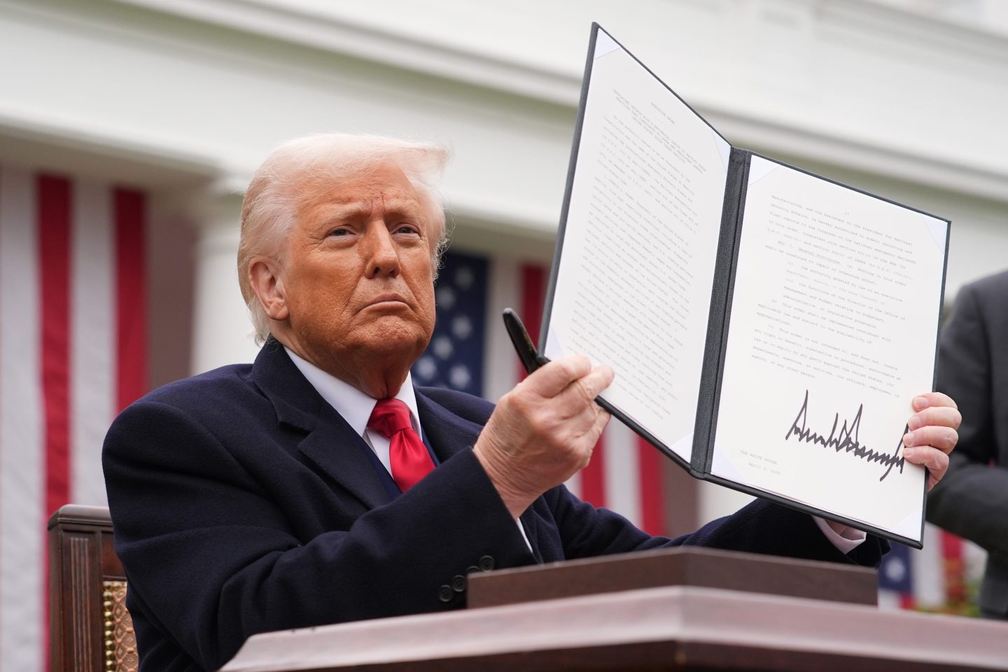 President Donald Trump displays a signed executive order imposing tariffs on imported goods, at the White House on April 2.
