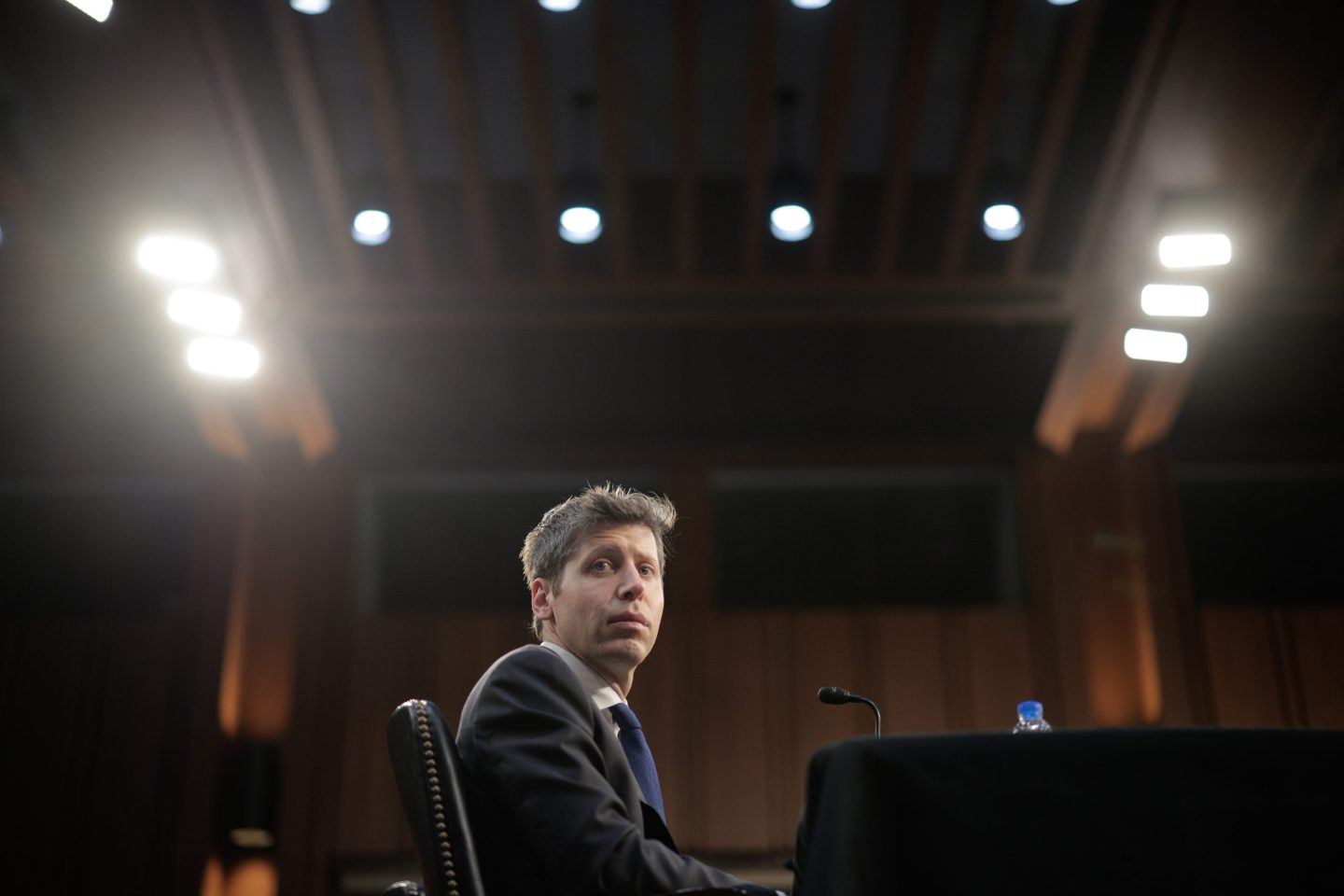 Sam Altman sits before the Senate Committee under bright lights.