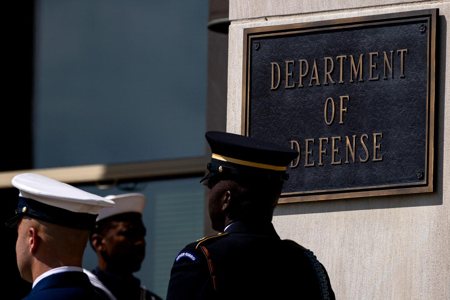 Soliders walk by the US D.O.D sign.