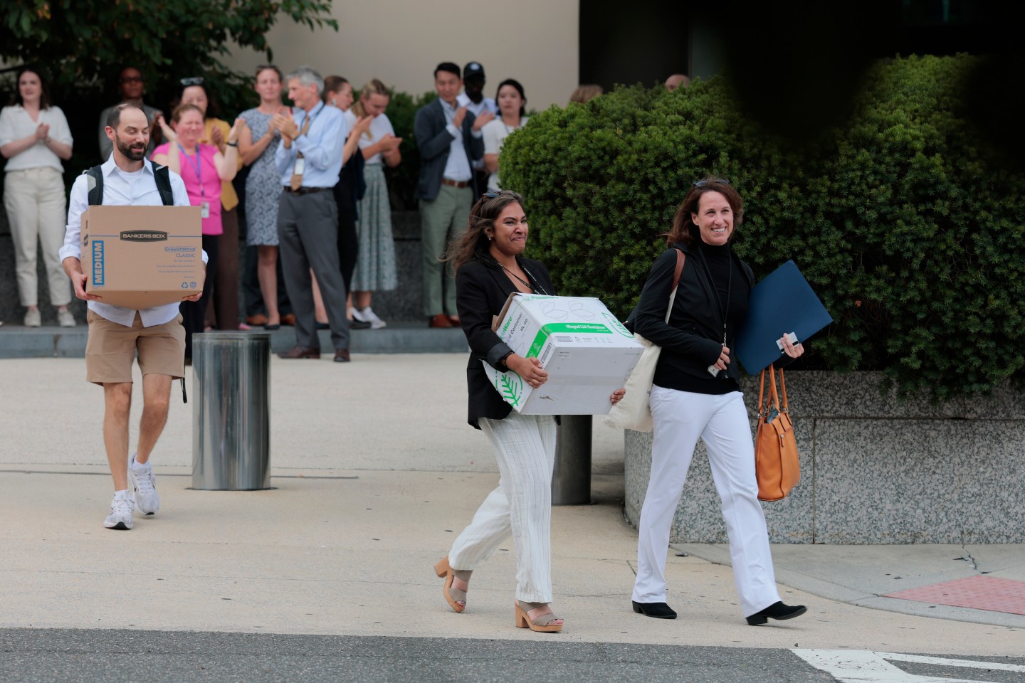 Federal workers carrying boxes after being laid off.