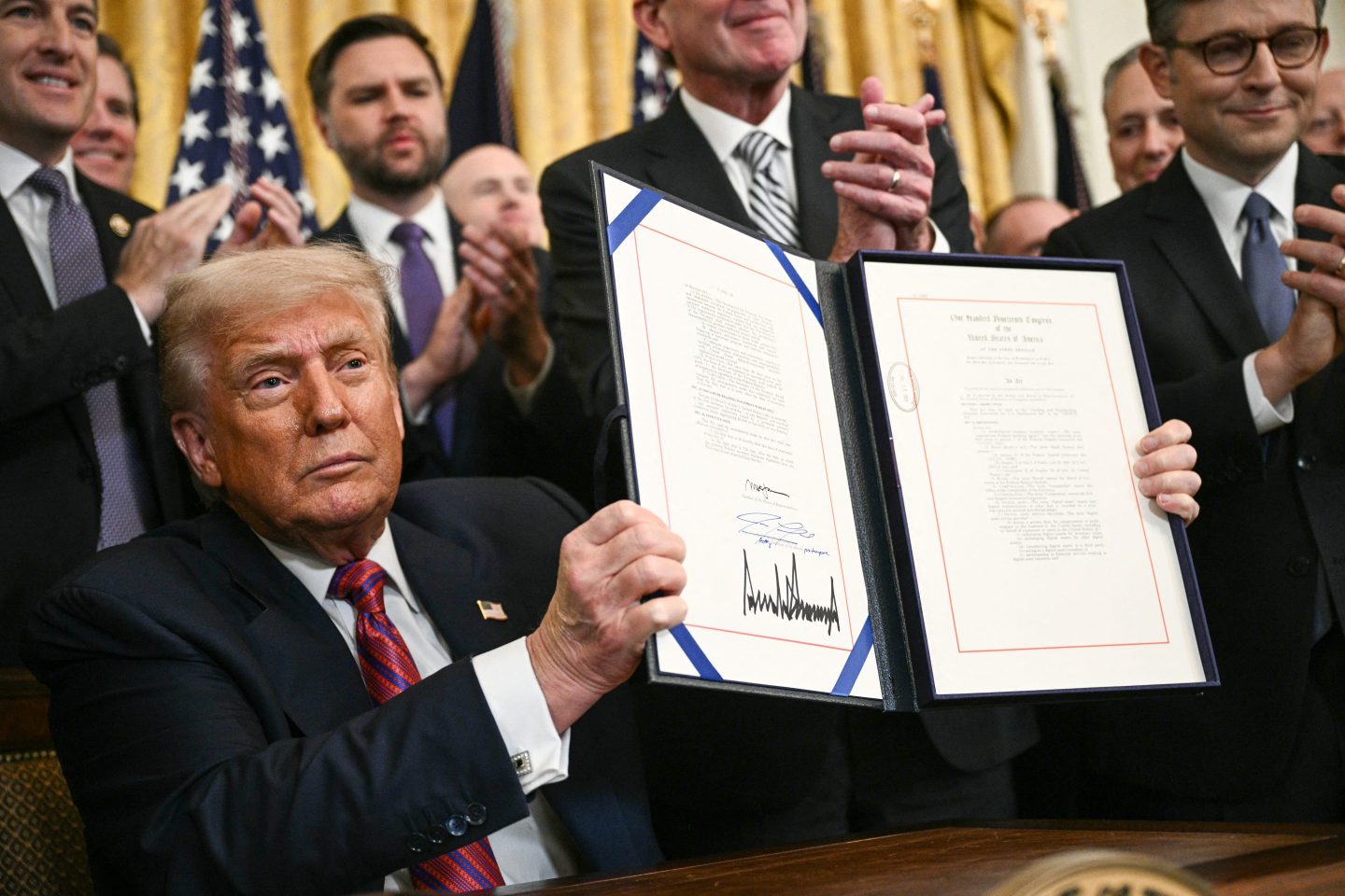 President Donald Trump displays the GENIUS Act (Guiding and Establishing National Innovation for US Stablecoins Act), US after signing it in the East Room of the White House in Washington, DC, on July 18, 2025.