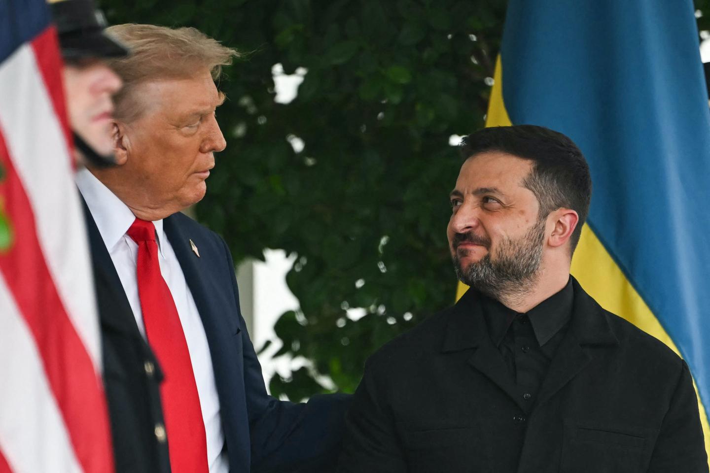 Zelenskyy looks up at Trump smilingly.