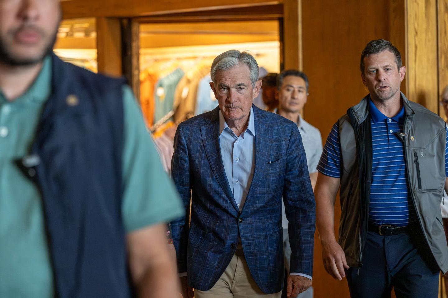 Federal Reserve chair Jerome Powell walks next to a few other people as he enters the Jackson Hole conference.