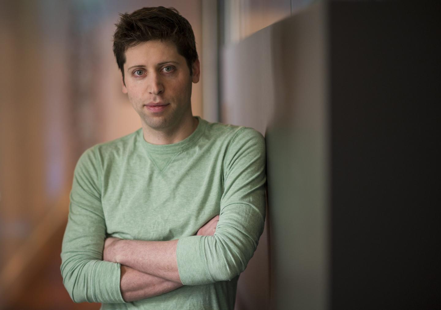 Sam Altman leans against a wall