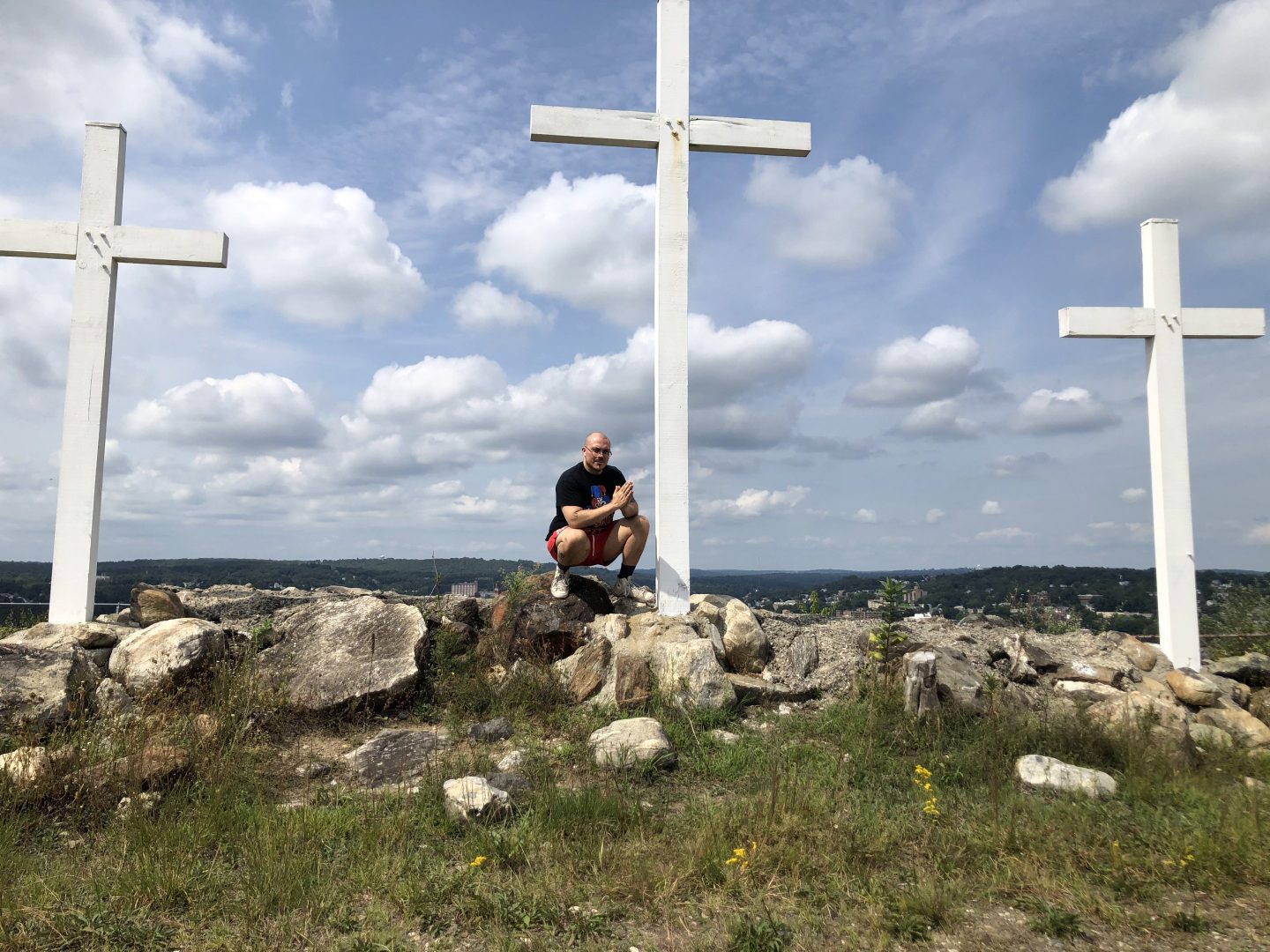 Anthony Fantano prays in front of a bunch of super-tall crosses